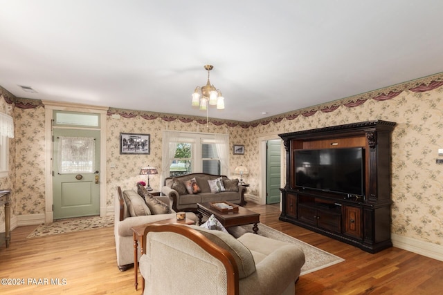 living room with light hardwood / wood-style flooring and an inviting chandelier