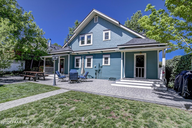 back of house with a yard and a patio