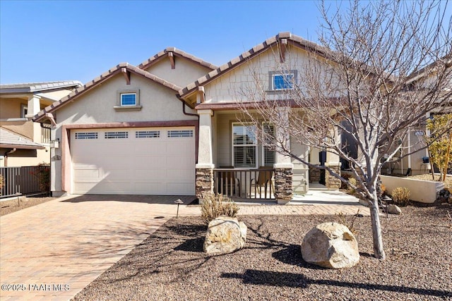 craftsman-style house with a garage, fence, a tiled roof, decorative driveway, and stucco siding