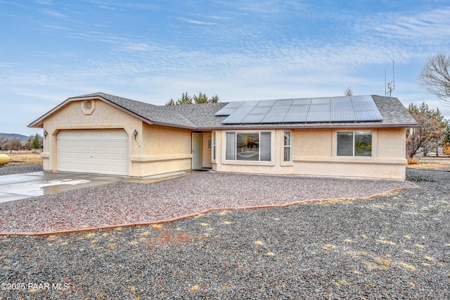 view of front of home featuring roof mounted solar panels, stucco siding, an attached garage, and concrete driveway