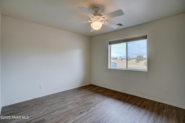 unfurnished room featuring baseboards, ceiling fan, visible vents, and wood finished floors