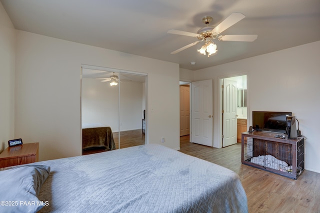 bedroom featuring a closet, ensuite bath, ceiling fan, and wood finished floors