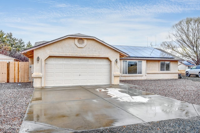 single story home featuring driveway, stucco siding, fence, and solar panels