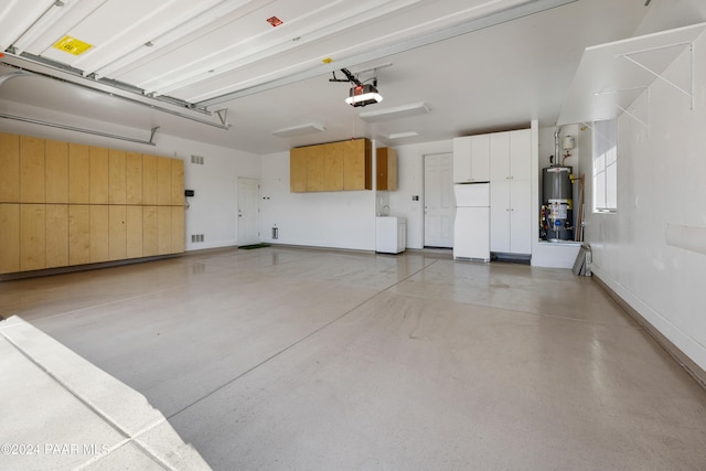 garage with white fridge, a garage door opener, and gas water heater