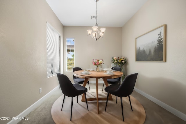 carpeted dining room featuring a notable chandelier