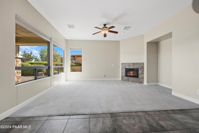 unfurnished living room featuring carpet flooring, ceiling fan, and a fireplace