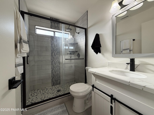 bathroom with an enclosed shower, vanity, and toilet