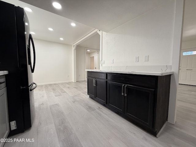 kitchen featuring black fridge with ice dispenser and light hardwood / wood-style floors