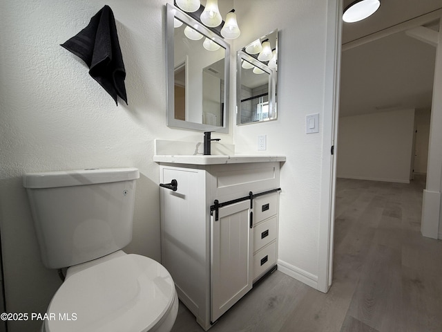 bathroom with vanity, hardwood / wood-style floors, and toilet