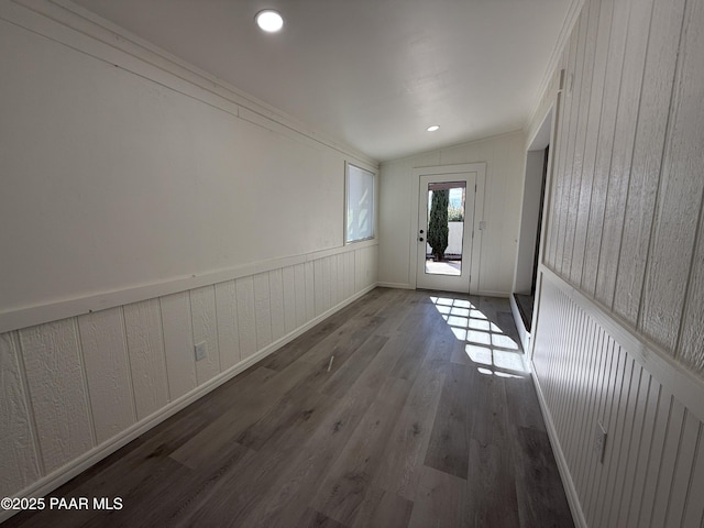 doorway featuring lofted ceiling, ornamental molding, and dark hardwood / wood-style flooring