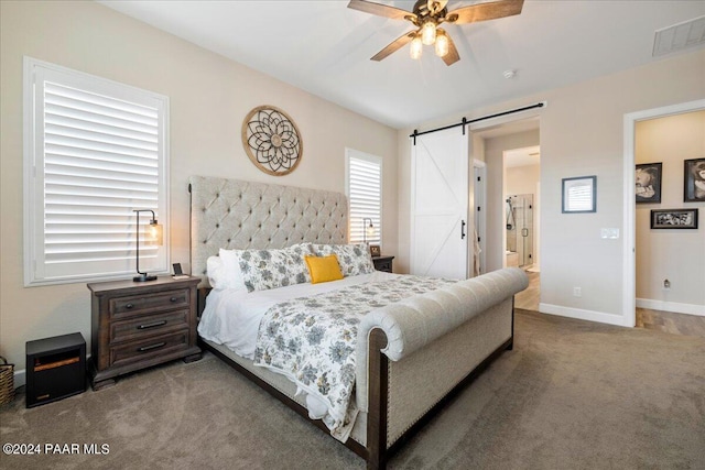 carpeted bedroom with a barn door and ceiling fan