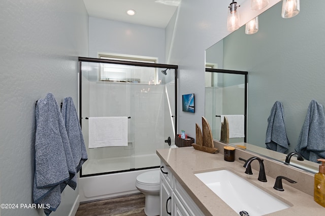 full bathroom featuring shower / bath combination with glass door, wood-type flooring, vanity, and toilet