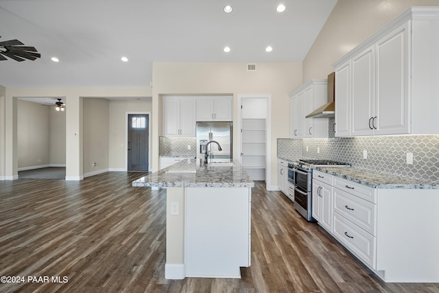 kitchen featuring white cabinets, ceiling fan, wall chimney exhaust hood, appliances with stainless steel finishes, and dark hardwood / wood-style flooring