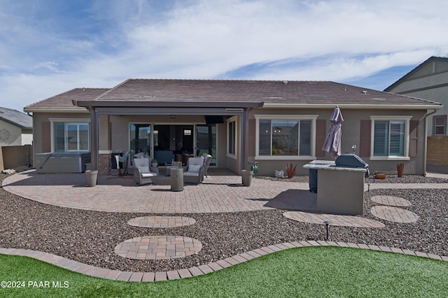 back of house with outdoor lounge area, a patio, and a hot tub