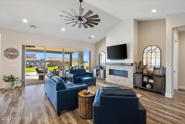 living room featuring a fireplace, ceiling fan, dark wood-type flooring, and high vaulted ceiling