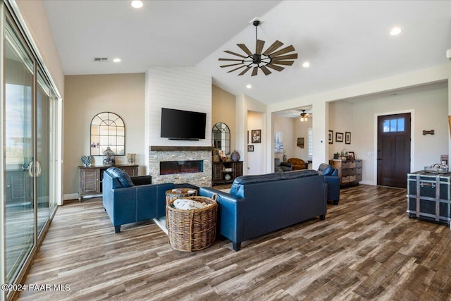 living room with hardwood / wood-style floors, a large fireplace, vaulted ceiling, and ceiling fan