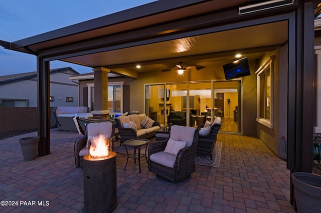 patio terrace at dusk featuring an outdoor hangout area and a jacuzzi