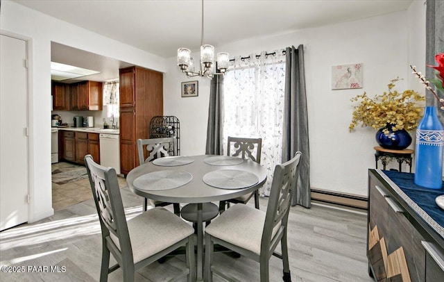 dining room featuring light wood finished floors, baseboard heating, and an inviting chandelier