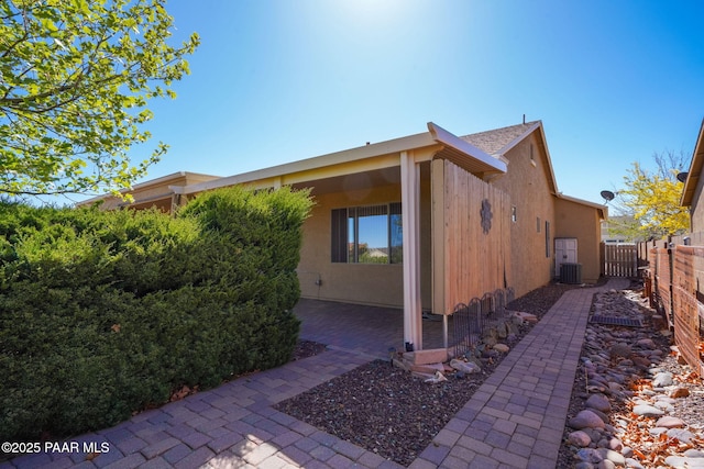 view of home's exterior with fence, a patio, and cooling unit
