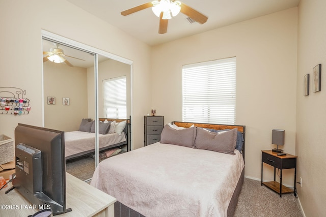 carpeted bedroom featuring a closet, baseboards, a ceiling fan, and visible vents