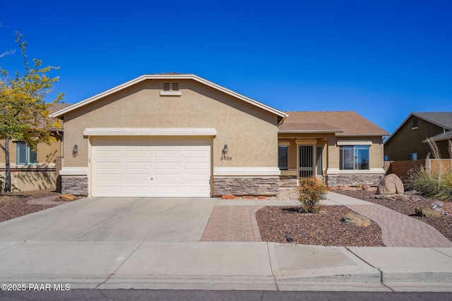 ranch-style home with fence, stone siding, stucco siding, an attached garage, and driveway