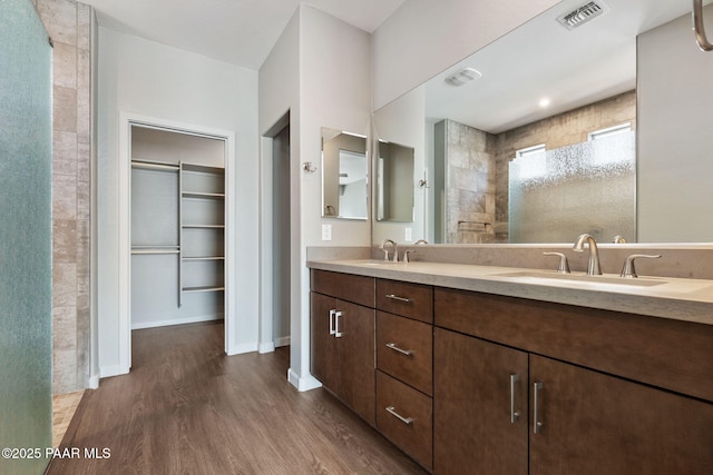 5248 Tranquil Bluff Way, Prescott, AZ 86301 - bathroom featuring wood finished floors, a tile shower, a spacious closet, and double vanity