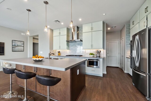 5248 Tranquil Bluff Way, Prescott, AZ 86301 - kitchen with stainless steel appliances, wall chimney range hood, a sink, tasteful backsplash, and dark wood-style floors