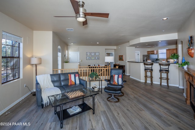 living room with a wealth of natural light, hardwood / wood-style floors, and ceiling fan