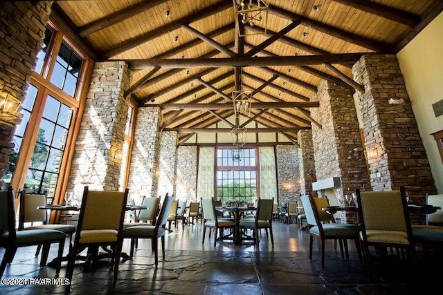 dining space featuring plenty of natural light, beam ceiling, wood ceiling, and a high ceiling