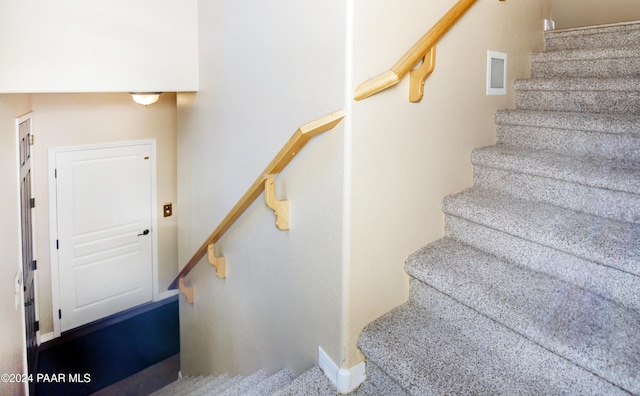 stairway featuring carpet