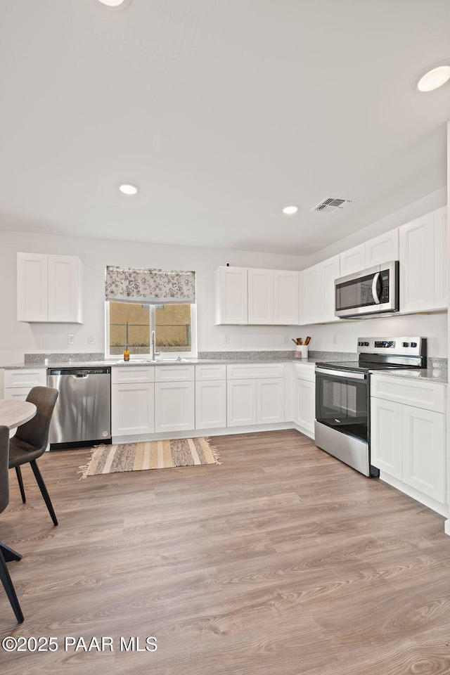 20163 E Cedar Canyon Dr, Mayer, AZ 86333 - kitchen featuring appliances with stainless steel finishes, white cabinetry, light countertops, recessed lighting, and light wood finished floors
