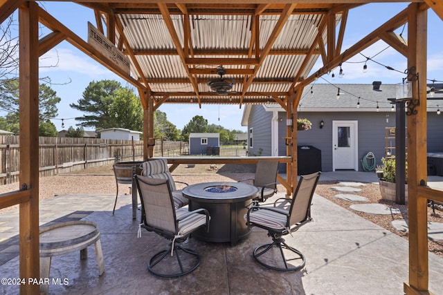 view of patio / terrace with a fire pit, a storage shed, and grilling area