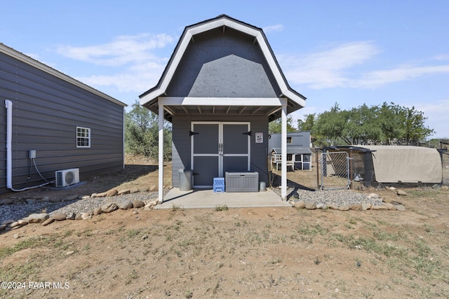 rear view of house featuring ac unit and a shed