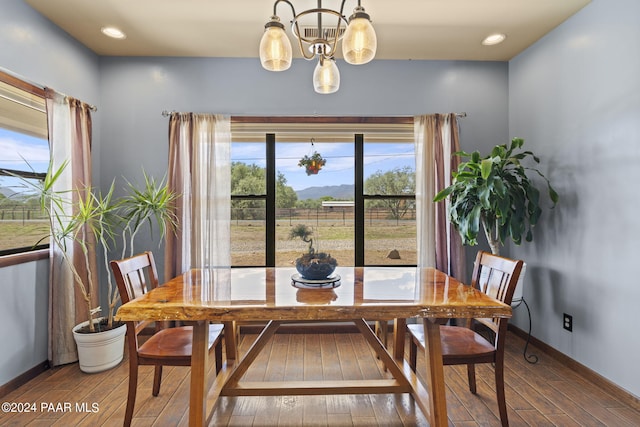 dining area featuring wood-type flooring and a notable chandelier