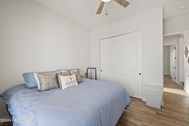 bedroom with hardwood / wood-style floors, ceiling fan, and a closet