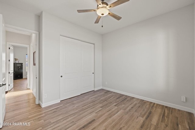 unfurnished bedroom with ceiling fan, a closet, and light hardwood / wood-style floors