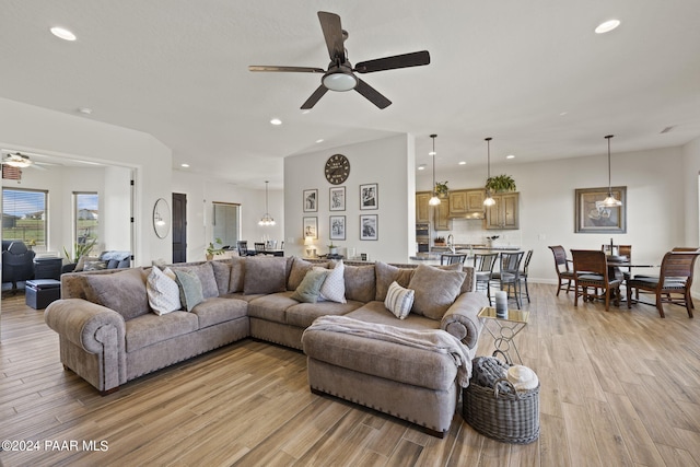 living room featuring ceiling fan and light wood-type flooring