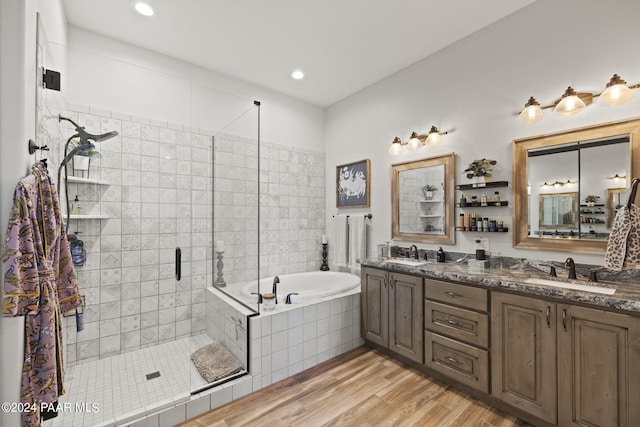 bathroom with hardwood / wood-style floors, vanity, and shower with separate bathtub