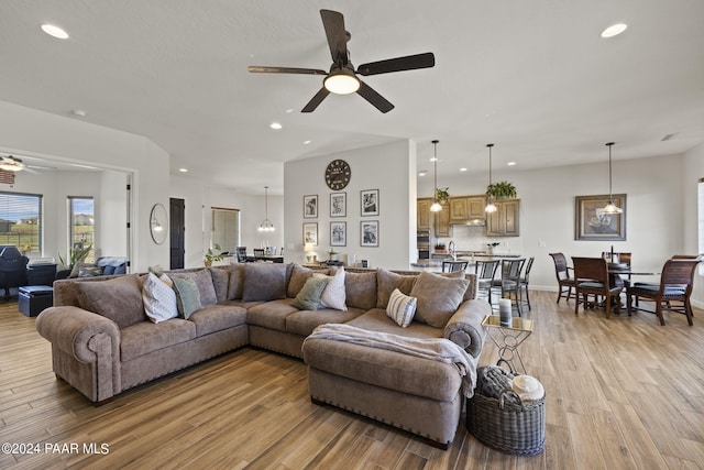 living room with light hardwood / wood-style floors and ceiling fan