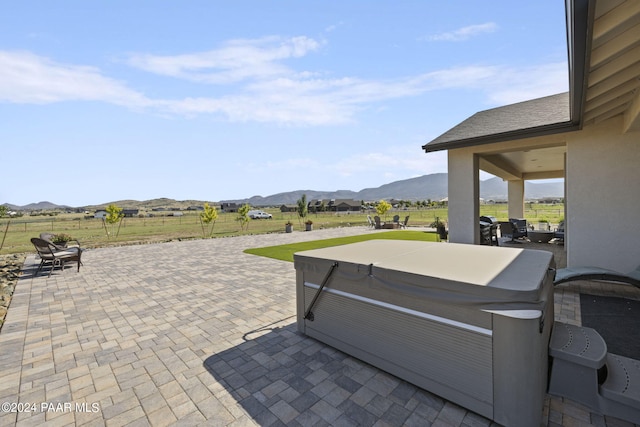 view of patio featuring a mountain view and a hot tub