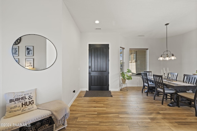 entryway with a chandelier and wood-type flooring