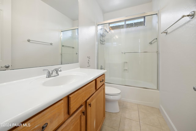 full bathroom with tile patterned flooring, vanity, bath / shower combo with glass door, and toilet