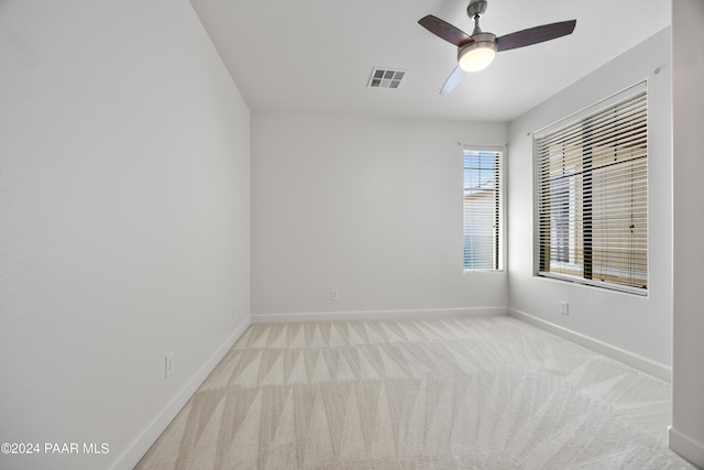 unfurnished room with light colored carpet and ceiling fan