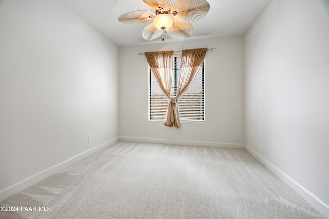 empty room featuring ceiling fan and light carpet