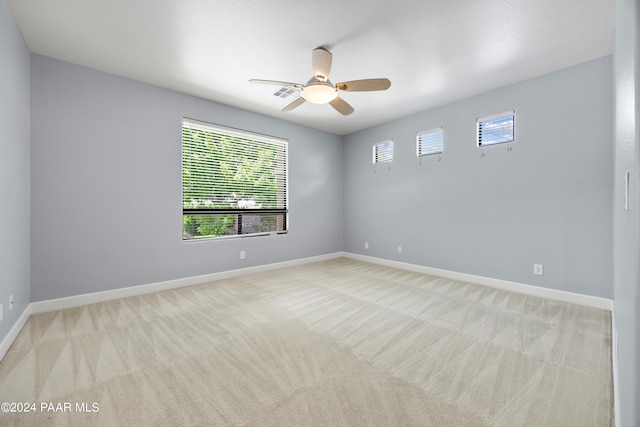 spare room featuring light carpet and ceiling fan