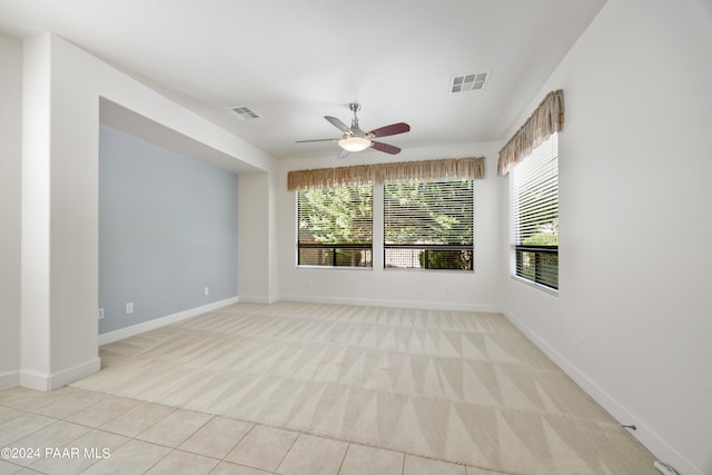 tiled spare room with ceiling fan