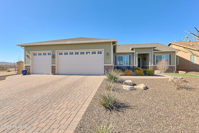 view of front of house with a garage, stone siding, and decorative driveway