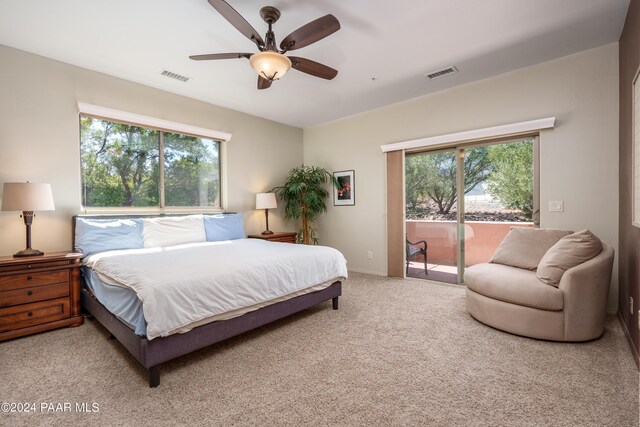 carpeted bedroom with access to outside, multiple windows, and ceiling fan