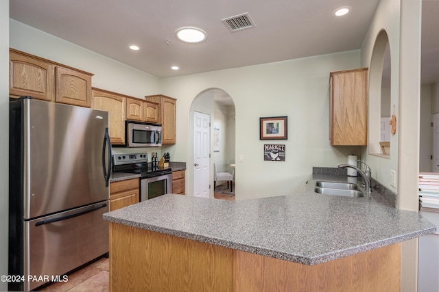 kitchen with sink, kitchen peninsula, stainless steel appliances, and light tile patterned floors