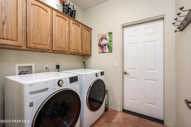 laundry area with washing machine and clothes dryer, tile patterned floors, and cabinets